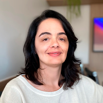 Gestora de Cria&ccedil;&atilde;o Digital Carolina Lobianco, ela &eacute; uma mulher branca, de cabelo liso, curto e preto. Est&aacute; sorrindo e vestindo uma blusa branca.