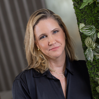 Gestora de Atendimento Danielle Baranowski, ela &eacute; uma mulher branca, de cabelo curto, liso e loiro. Est&aacute; sorrindo e vestindo uma blusa social preta.