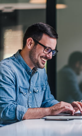 Homem branco, com cabelo curto e &oacute;culos, mexendo no notebook.